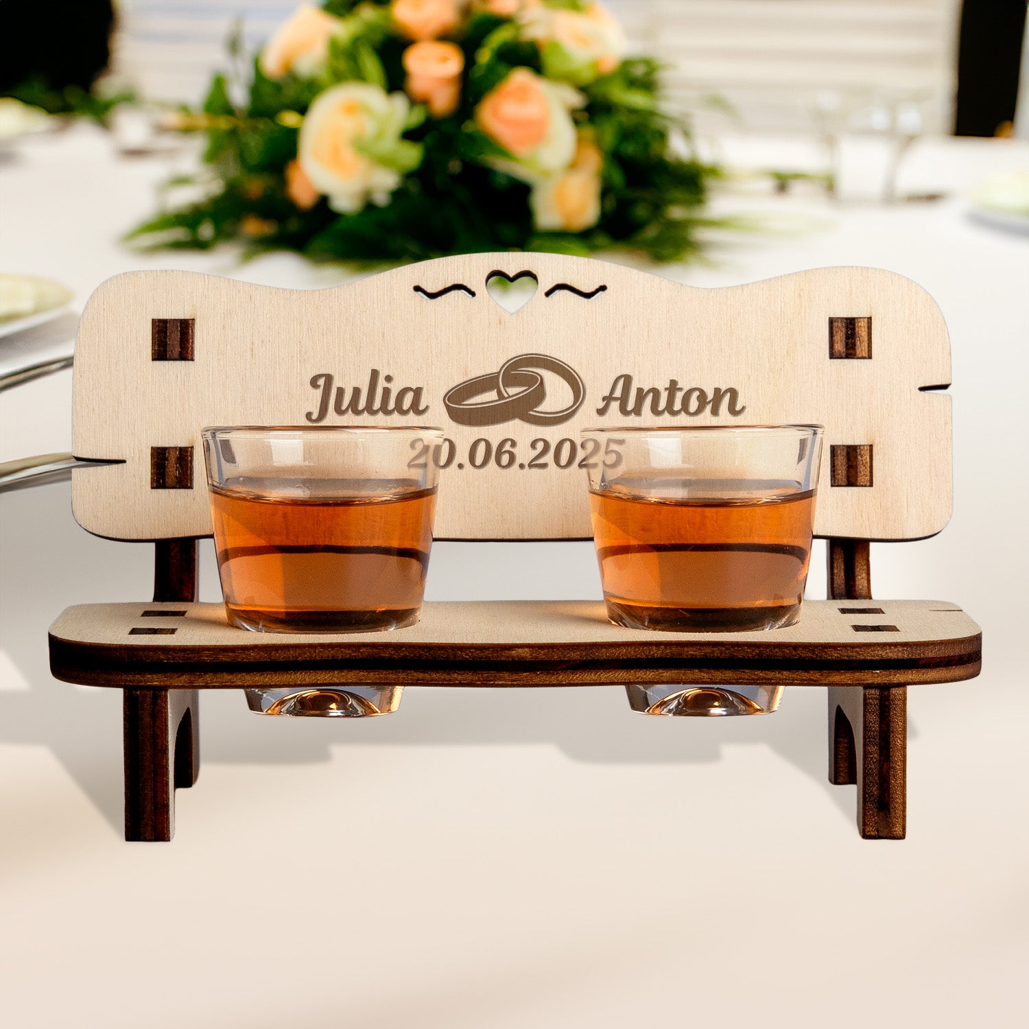 Charming personalized wedding gift - a wooden schnapps bench with engraved names and date, featuring two shot glasses and a heart cutout.