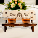 Charming personalized wedding gift - a wooden schnapps bench with engraved names and date, featuring two shot glasses and a heart cutout.