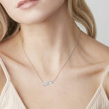 Halskette mit Unendlichkeitssymbol und funkelndem Stein